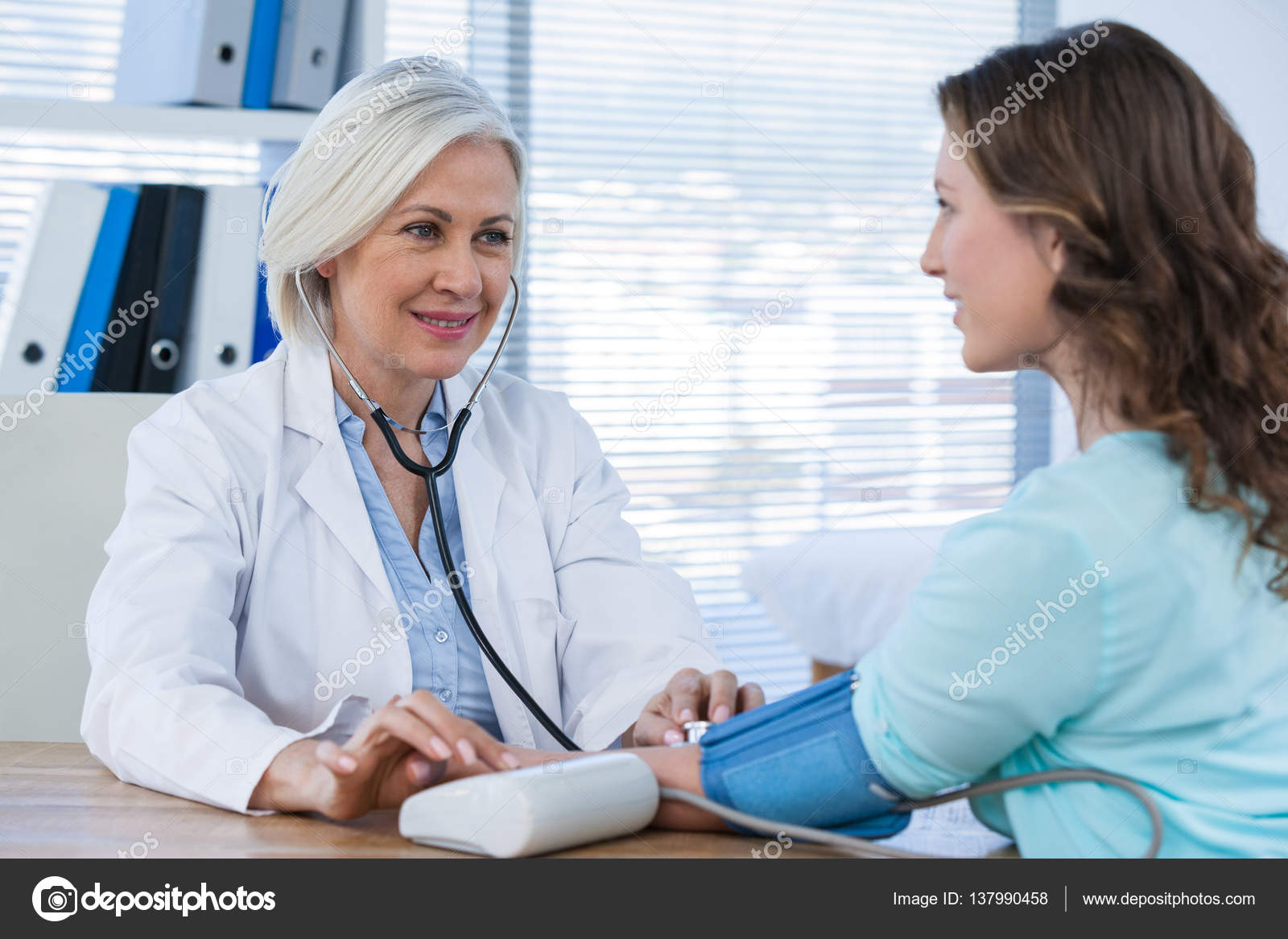 Female doctor checking blood pressure of patient — Stock Photo