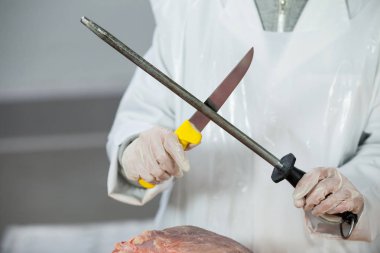 Female butcher sharpening his knife clipart