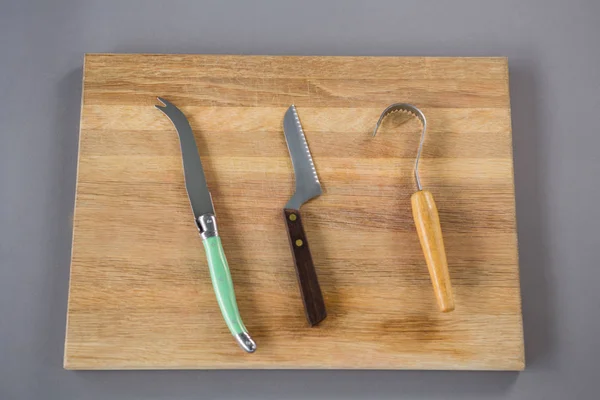 Cheese cutting tools on wooden board — Stock Photo, Image