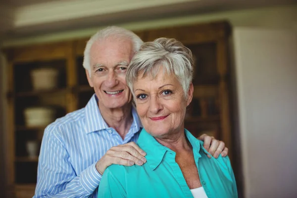 Seniorenpaar lächelt im Wohnzimmer — Stockfoto