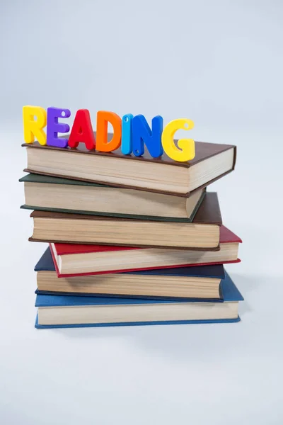 Reading letter blocks on stack of books — Stock Photo, Image