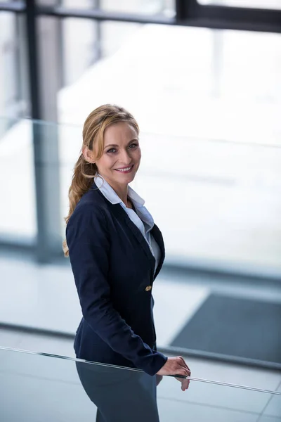 Mulher de negócios sorridente em pé no corredor — Fotografia de Stock