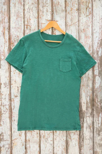 Green t-shirt with pocket on hanger — Stock Photo, Image