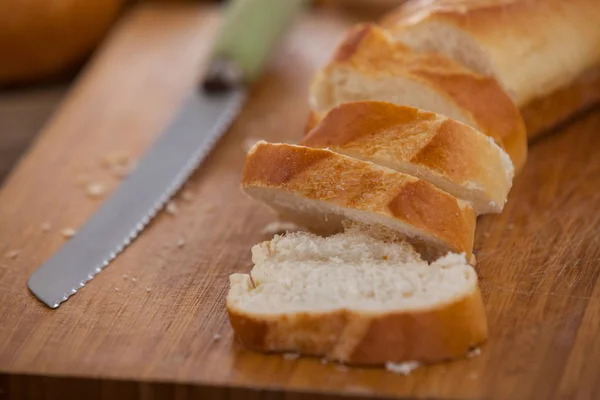 Sliced baguette with knife — Stock Photo, Image