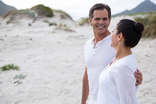 Счастливая пара, стоящая на пляже — стоковое фото