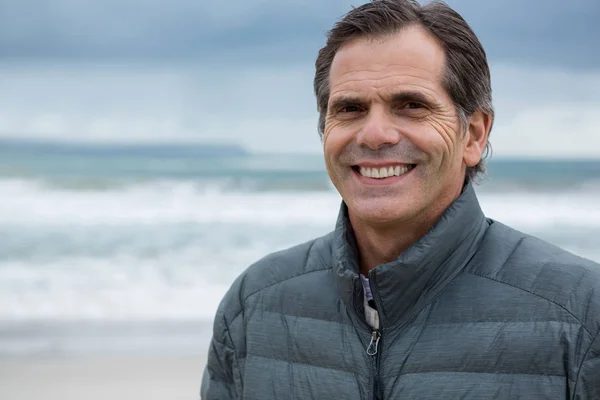 Uomo sorridente sulla spiaggia — Foto Stock