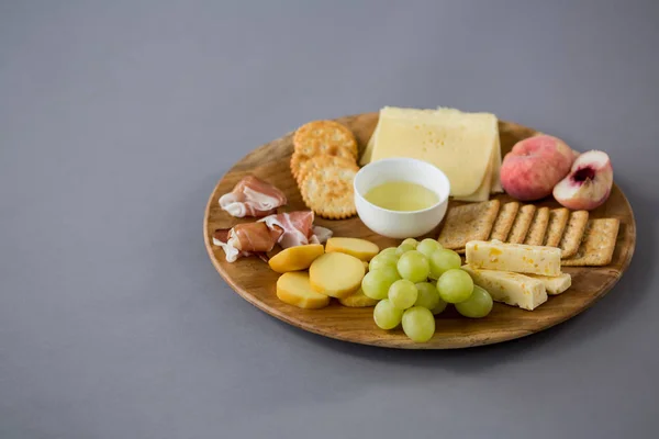 Queso con uvas, melocotón, carne y galletas saladas —  Fotos de Stock