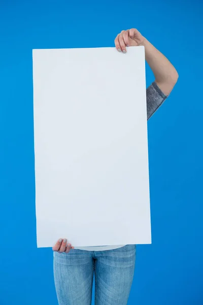 Mulher segurando um cartaz em branco na frente da cara — Fotografia de Stock