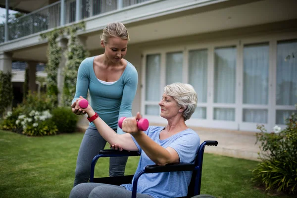 Trainer unterstützt Frau bei der Durchführung von Übungen — Stockfoto