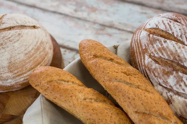 Ahşap masa üstünde ekmek somunları — Stok fotoğraf