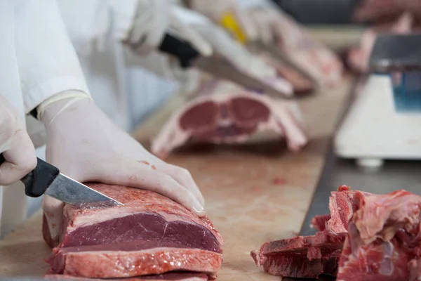 Tukang daging memotong daging di pabrik daging — Stok Foto