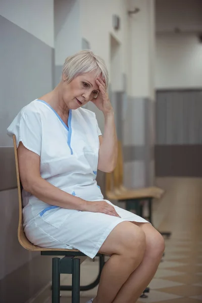 Enfermeira feminina tensa sentada na cadeira — Fotografia de Stock