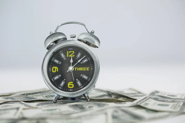 Relógio despertador com dólares — Fotografia de Stock