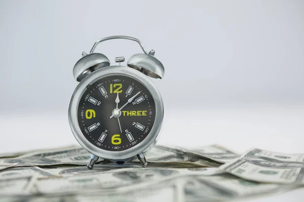 Alarm clock with dollars — Stock Photo, Image