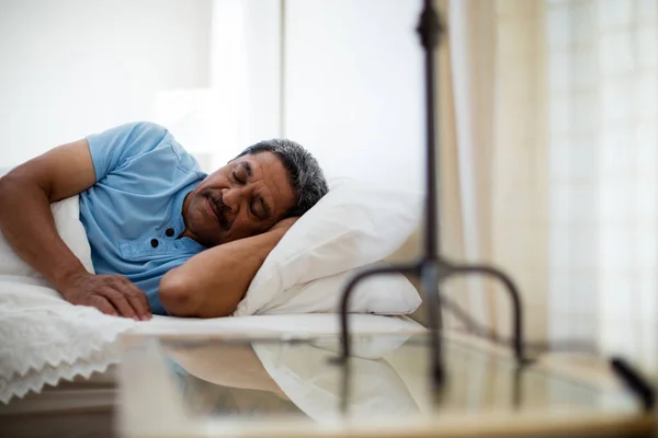 Senior ruht sich auf Bett aus — Stockfoto