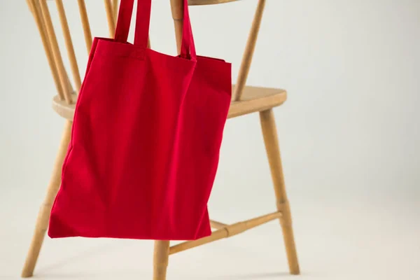 Красная сумка висит на деревянном стуле — стоковое фото