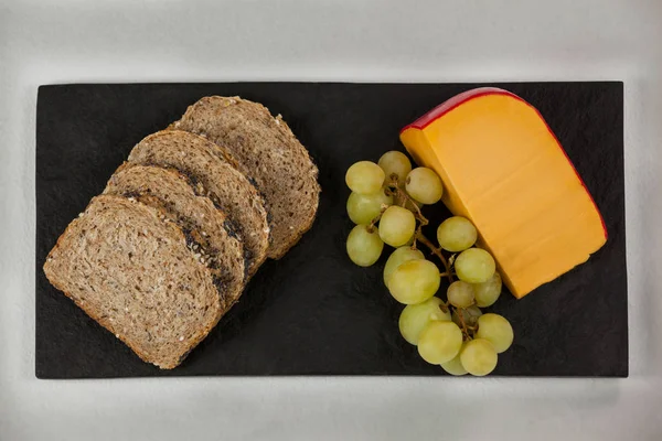 Slices of brown bread, grapes and gouda cheese — Stock Photo, Image