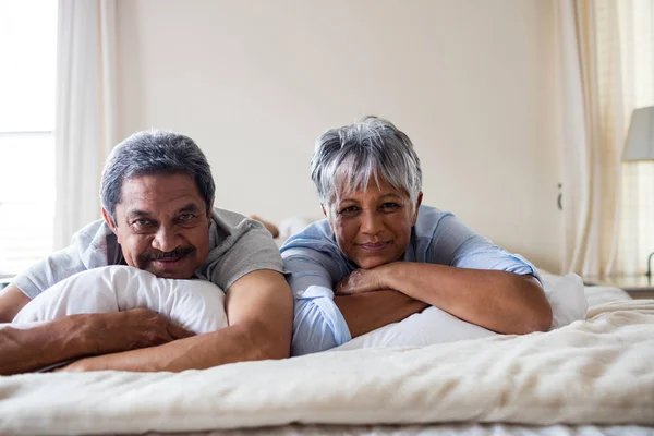 Felice coppia anziana sdraiata sul letto — Foto Stock