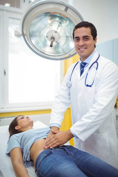 Läkaren undersöker magen av en kvinnlig patient — Stockfoto