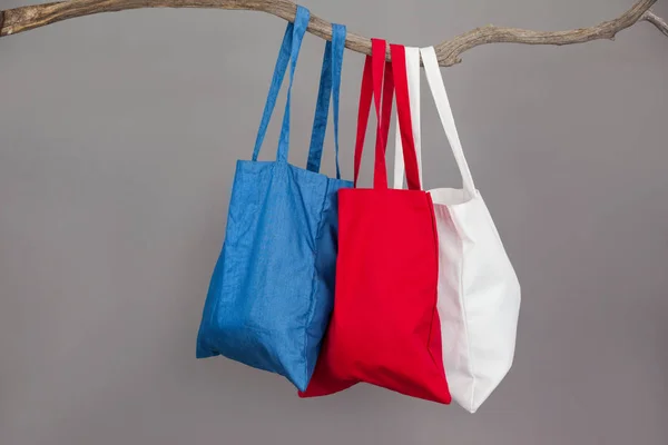 Bolsas de compras coloridas colgando en la rama del árbol —  Fotos de Stock