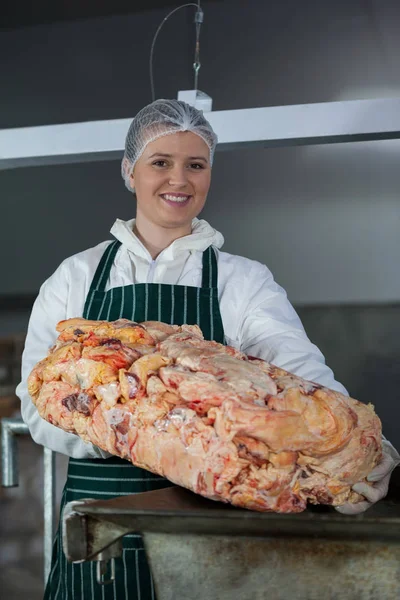 Butcher holding raw meat at meat factory — Stock Photo, Image