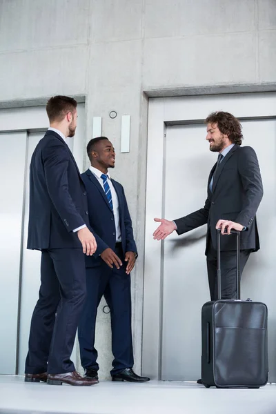 Les hommes d'affaires parlent en attendant l'ascenseur — Photo