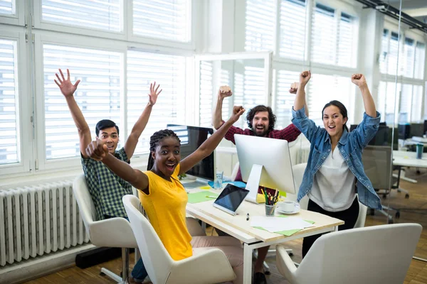 Företagsledare med armar upp på skrivbord — Stockfoto