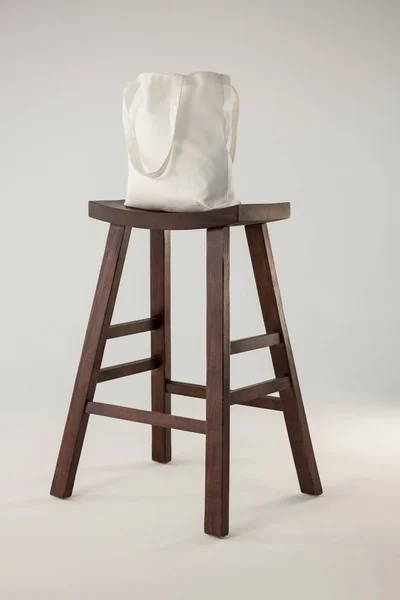 Белая сумка на деревянном стуле — стоковое фото