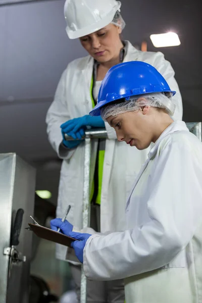 Technici onderzoeken vlees processing machine — Stockfoto