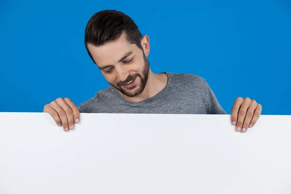 Handsome man holding a blank placard — Stock Photo, Image
