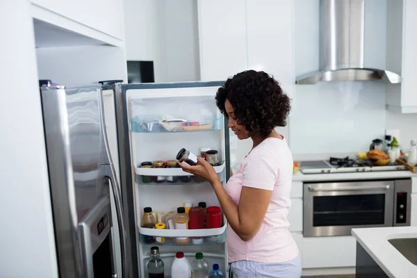 Mujer quitando la botella del refrigerador — Foto de Stock