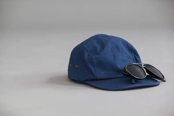 Синя шапка з сонцезахисними окулярами — стокове фото