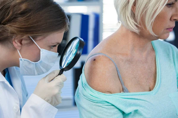 Dermatologe untersucht Maulwurf einer Patientin — Stockfoto