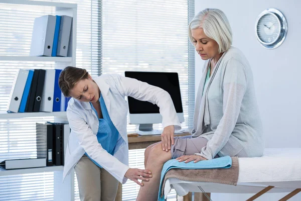 Médico examinando joelho paciente — Fotografia de Stock