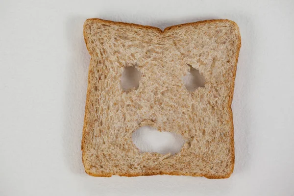 Улыбающееся лицо на ломтике хлеба — стоковое фото