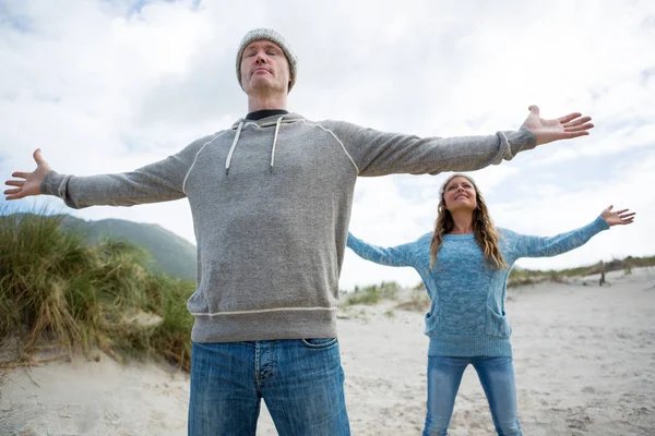 Couple standing with arms outstretched — Stock Photo, Image