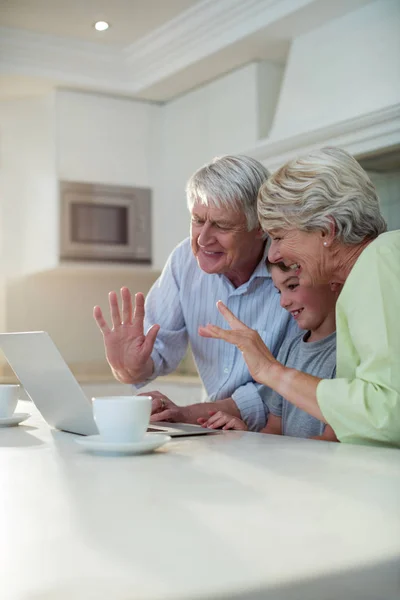 Grandson using laptop with grandparents — Stock Photo, Image