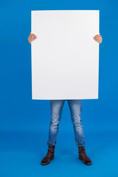 Hombre sosteniendo un cartel en blanco delante de la cara — Foto de Stock