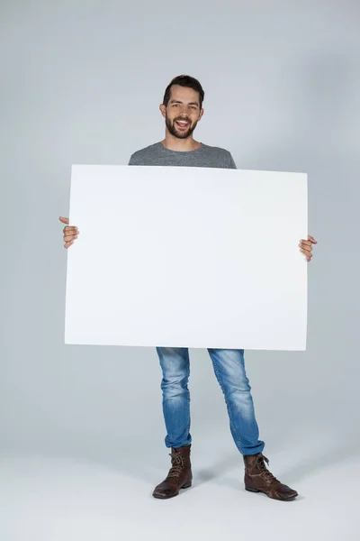 Schöner Mann mit einem leeren Plakat — Stockfoto
