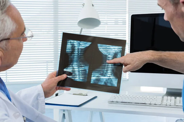 Хирург и врач обсуждают рентгеновский отчет — стоковое фото