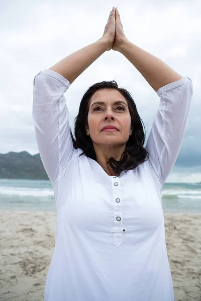 Femme effectuant du yoga sur la plage — Photo