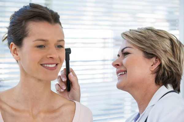 Läkaren undersöker patienter öra med otoskop — Stockfoto