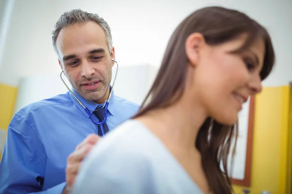 Läkaren undersöker en kvinnlig patient — Stockfoto