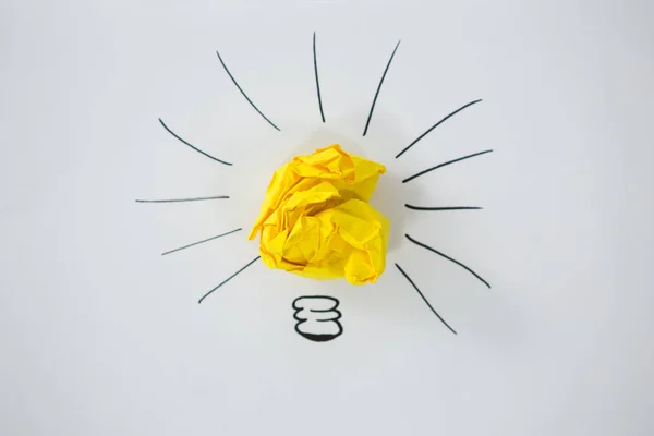 Light bulb drawn around crumbled Yellow paper — Stock Photo, Image