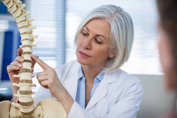 Arzt erklärt Patientin anatomische Wirbelsäule — Stockfoto