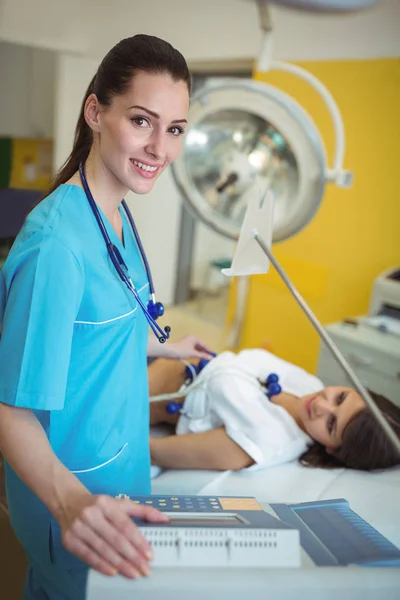 Enfermera realizando una prueba de electrocardiograma al paciente — Foto de Stock