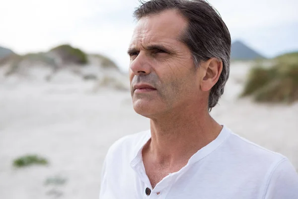 Hombre reflexivo de pie en la playa — Foto de Stock