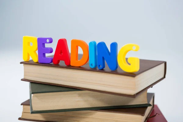 Reading letter blocks on stack of books — Stock Photo, Image