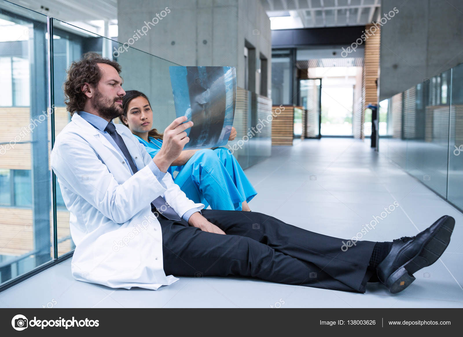 Stressed Doctor And Nurse Sitting On Floor Stock Photo