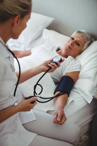 Nurse checking blood pressure of woman — Stock Photo, Image